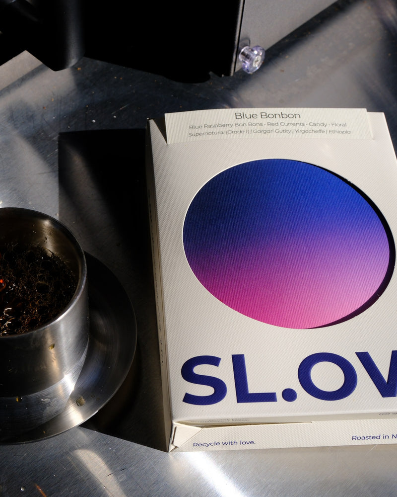 Blue Bonbon SL.OW box beside a cup of filter coffee being poured