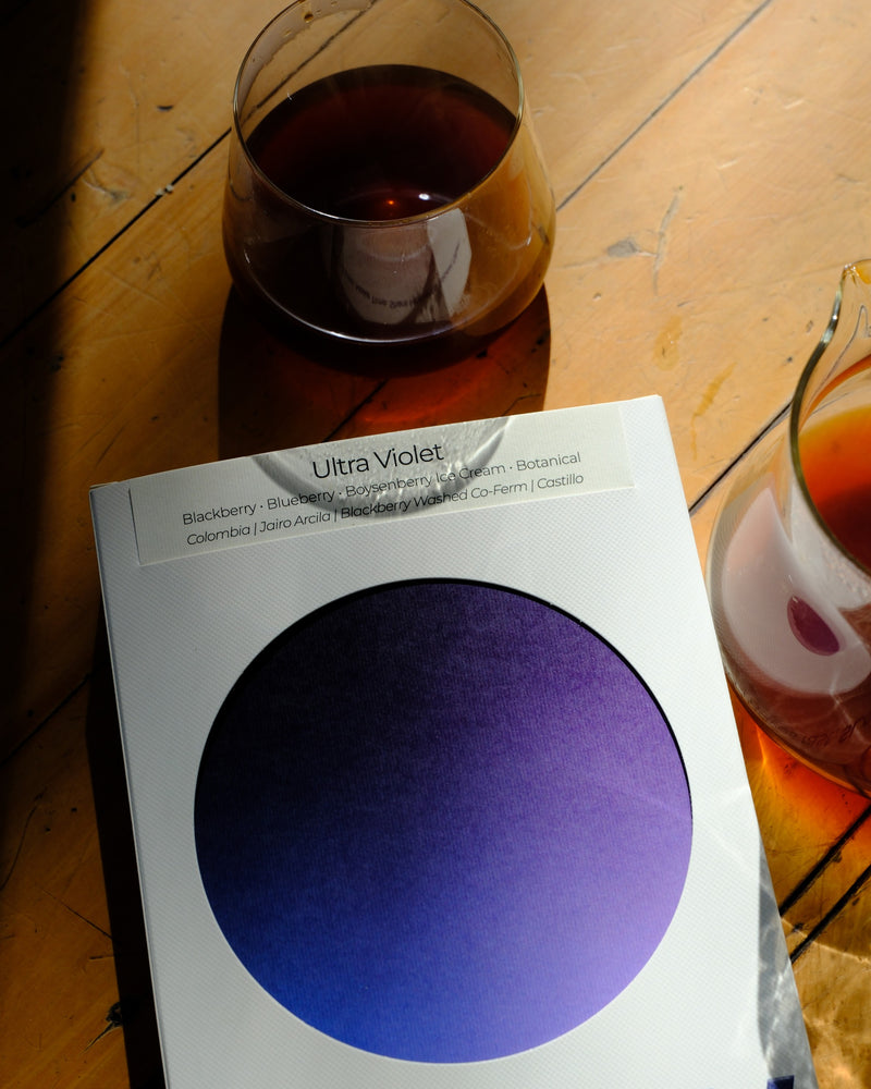Ultra Violet 200g box with black coffee in morning light